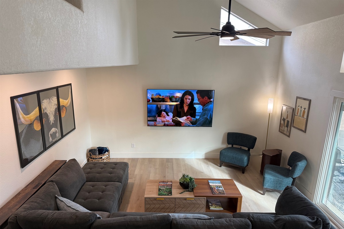 Large living room with a ton of seating & big screen smart TV