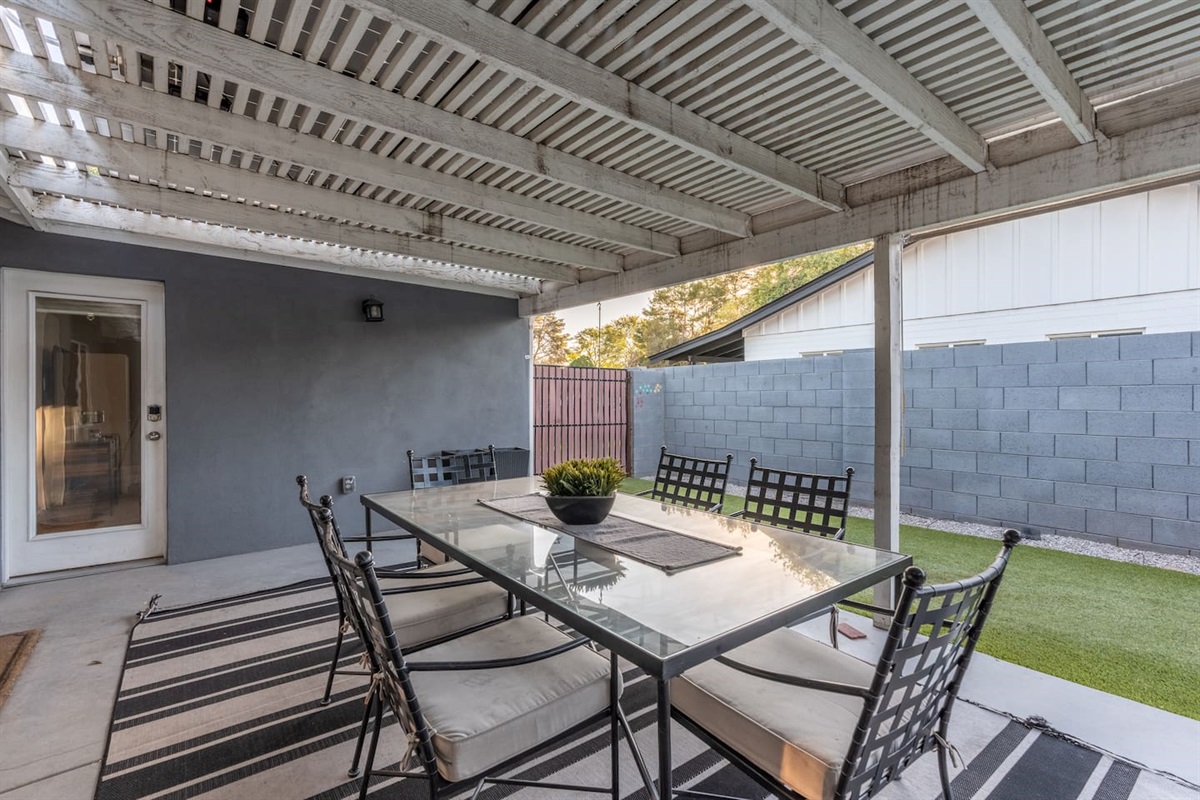 Charming backyard featuring a 6-seater dining table, perfect for outdoor meals and gatherings in a peaceful setting.
