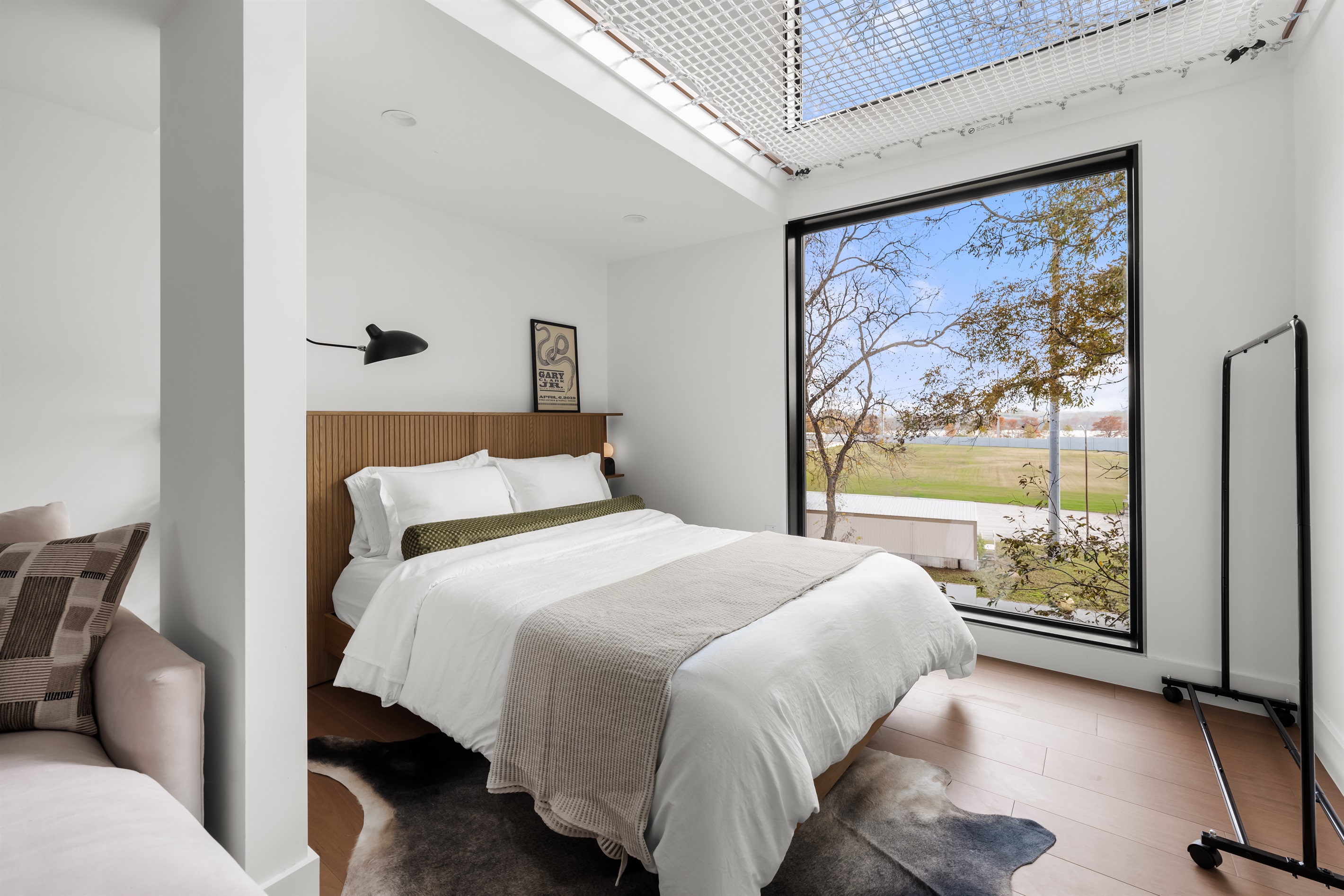 Serene bedroom retreat with large windows, soft natural light, and peaceful outdoor views—ideal for unwinding.