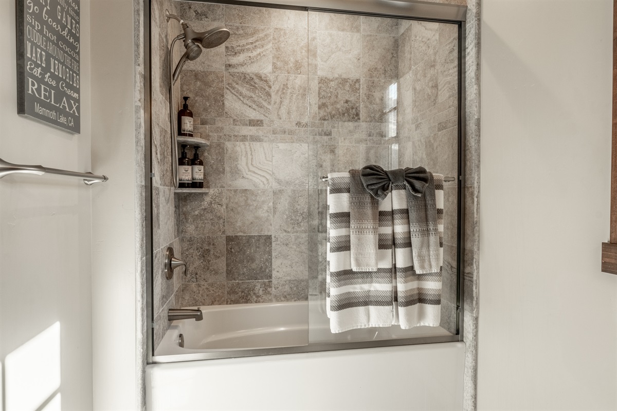 The main floor bath features a tub/shower, sink, and toilet—ready to keep everyone refreshed whether they’re coming from the living room or bunkroom.