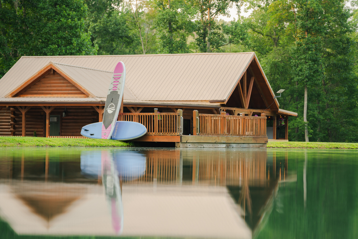 A peaceful pond framed by the cabin and surrounding woods, creating a beautiful backdrop for your getaway.