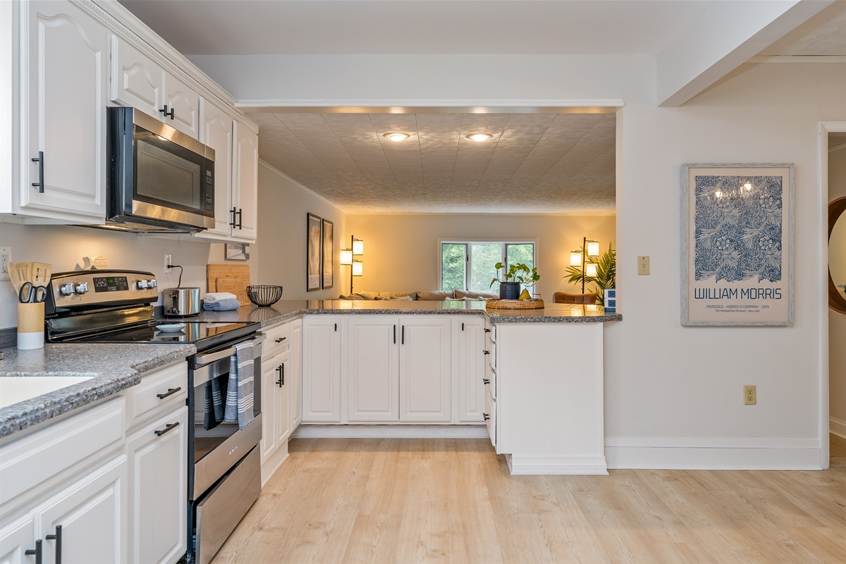 Open-concept kitchen with breakfast bar and scenic views into the cozy living room—ideal for entertaining and relaxing.