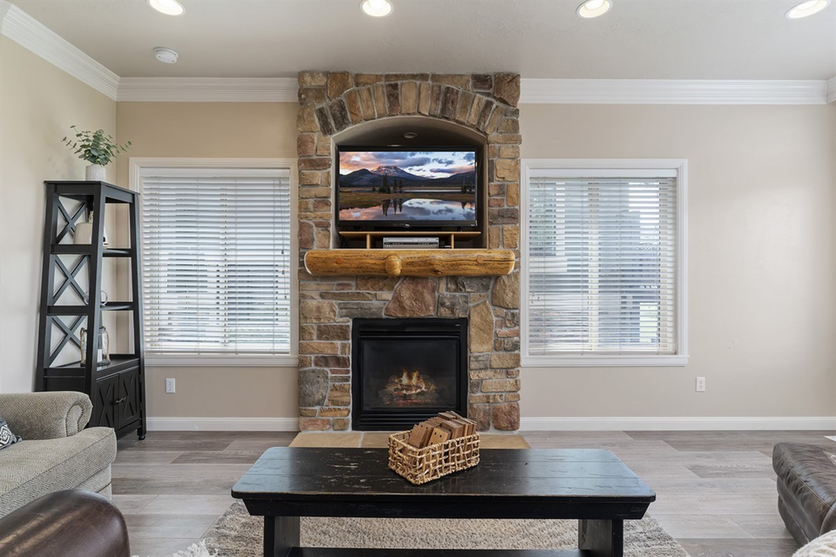 Cozy living room centered around a beautiful stone fireplace and TV—ideal for relaxing evenings.