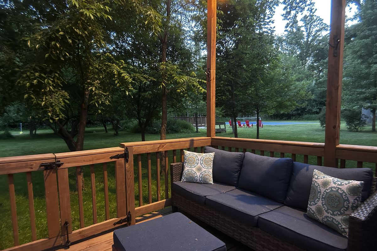 Large deck with seating. Pickleball court in background.