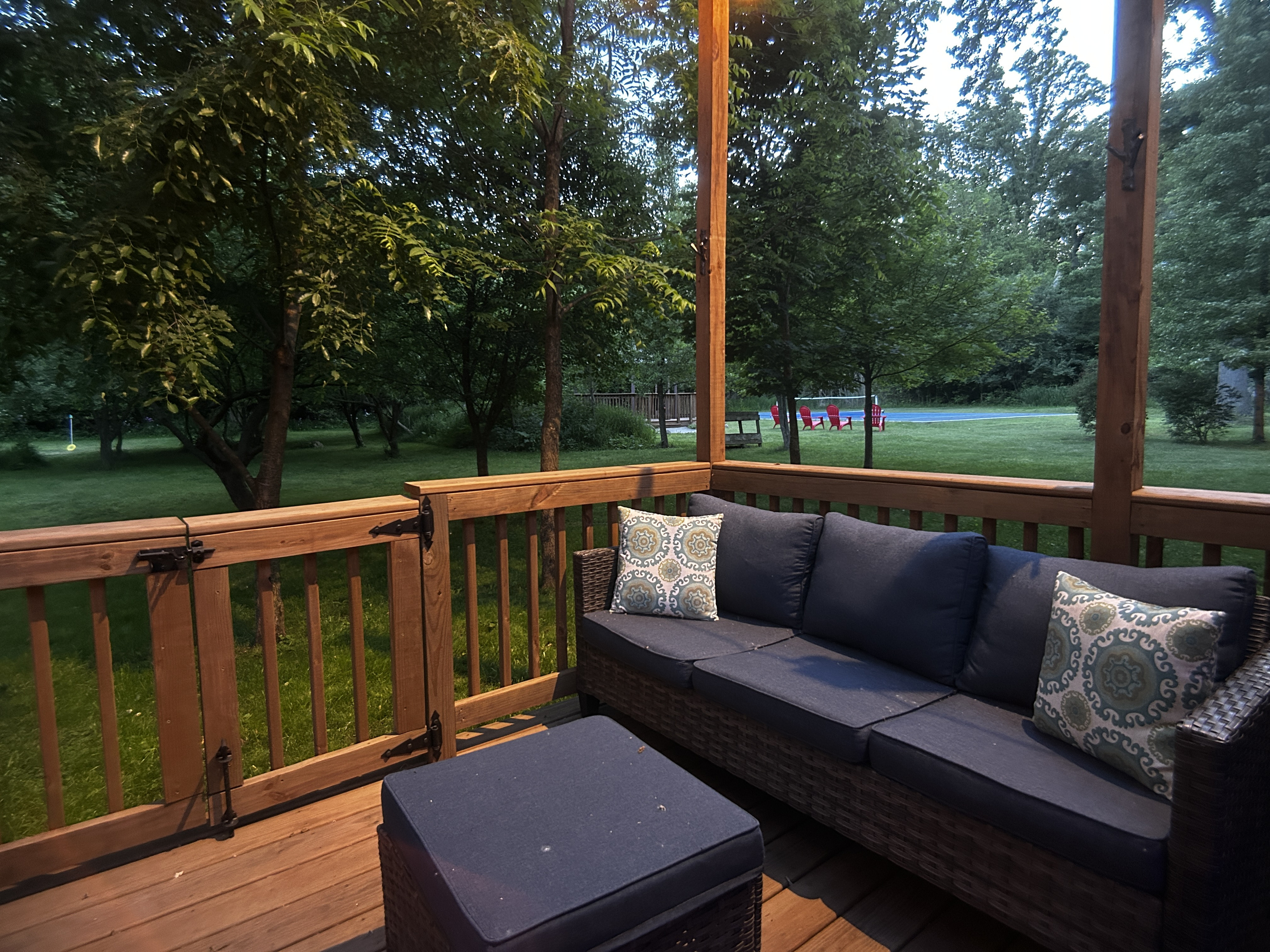 Large deck with seating. Pickleball court in background.