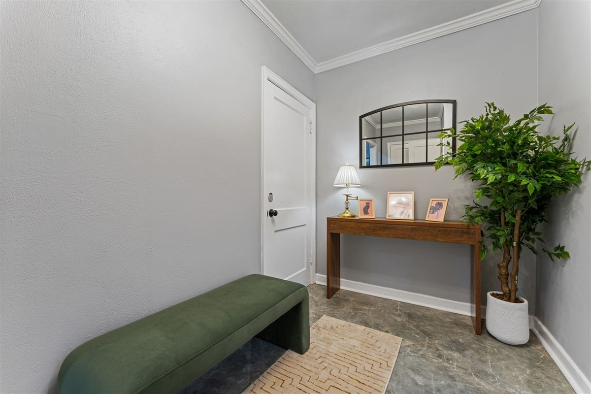 Enjoy a clean, elegant entryway with modern décor and a cozy bench.