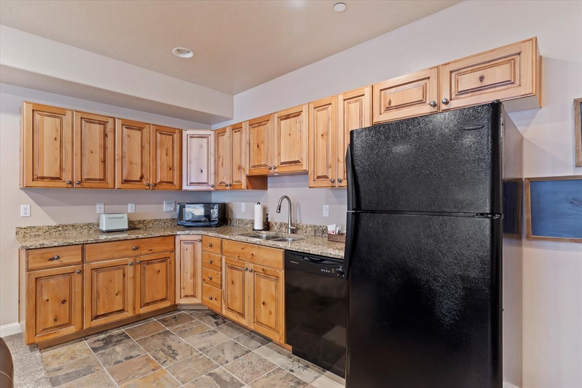 A fully equipped secondary kitchen with warm wood cabinetry and ample prep space—perfect for extended stays or entertaining.