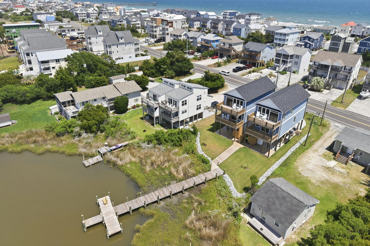 An elevated aerial perspective highlights the home's spacious lot, private boardwalk, and close proximity to both the marsh and the beach