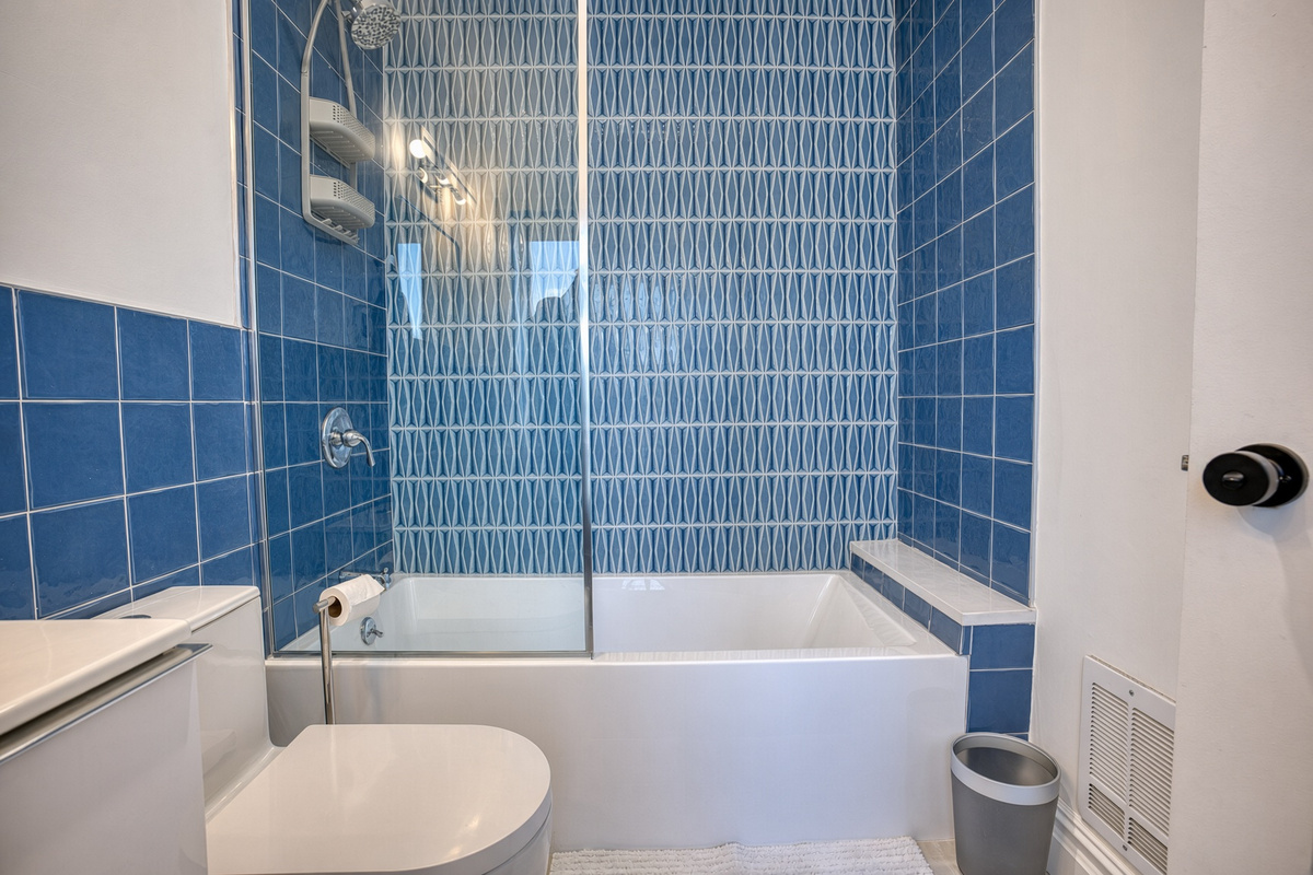 Full bathroom with modern tile setup. Heated floors for added comfort.