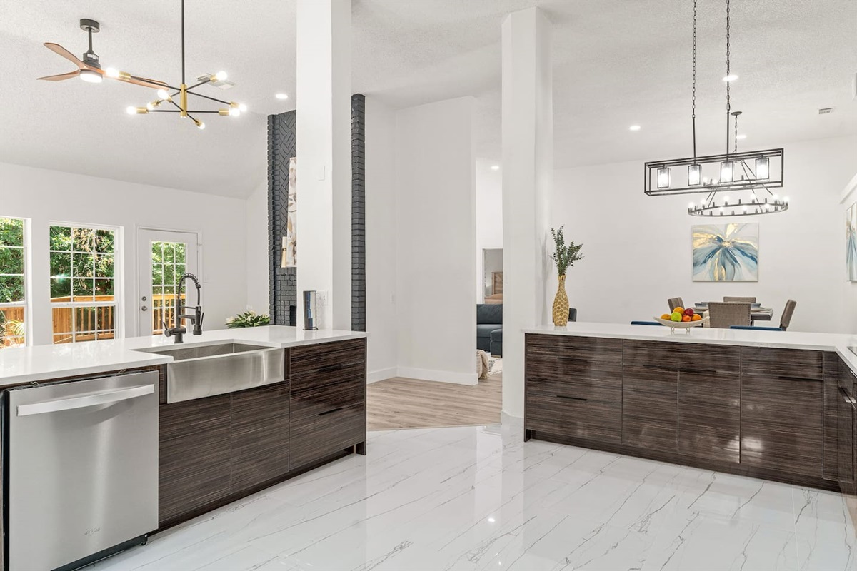 Sleek kitchen design perfect for preparing home-cooked meals featuring a deep sink, dish washer, and open concept kitchen into dining room.