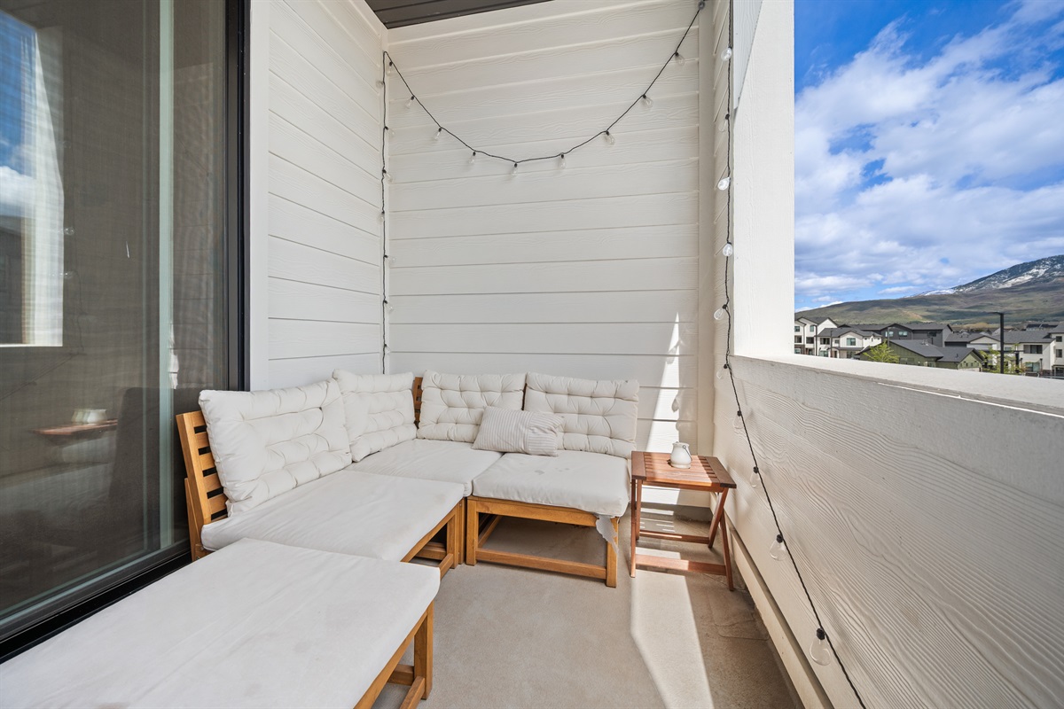 Private balcony with cozy seating and mountain views.