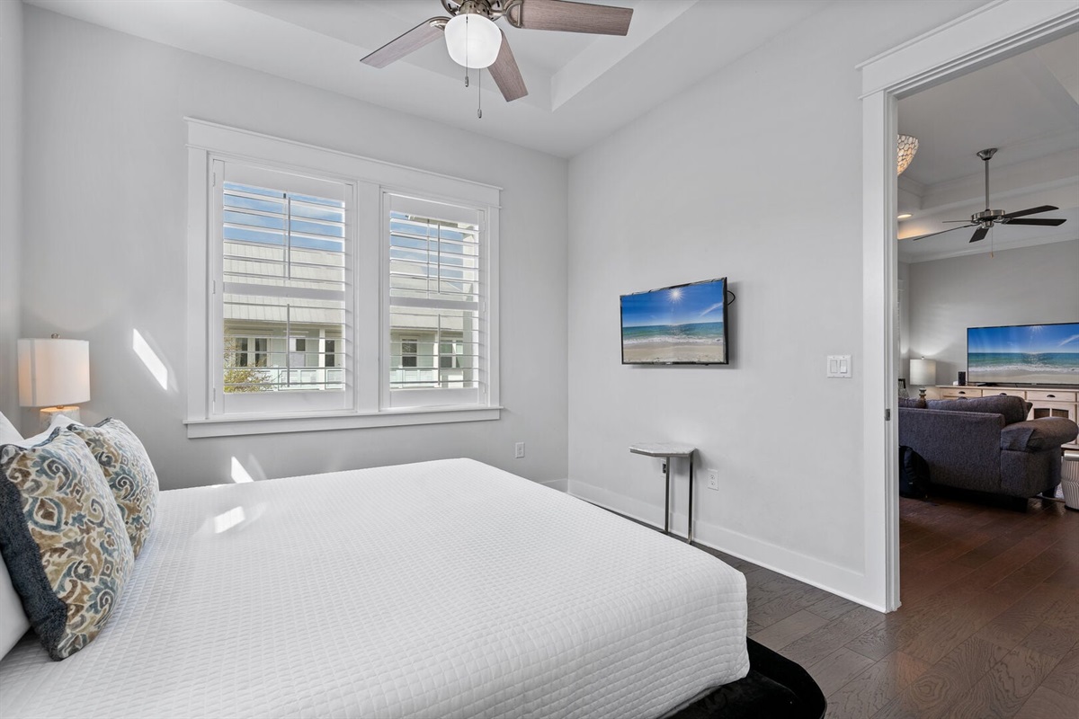 Guest bedroom with wall-mounted smart TV.