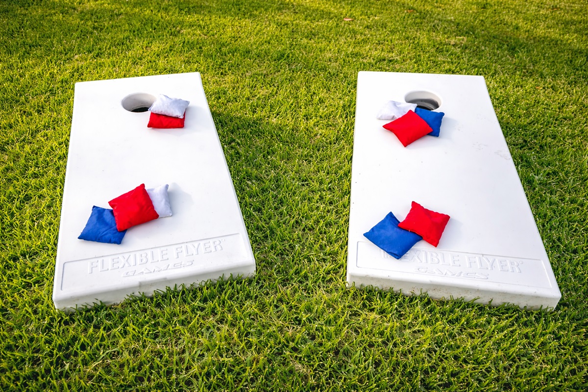 Spacious backyard with cornhole, lawn games, and open green space for kids and group activities.