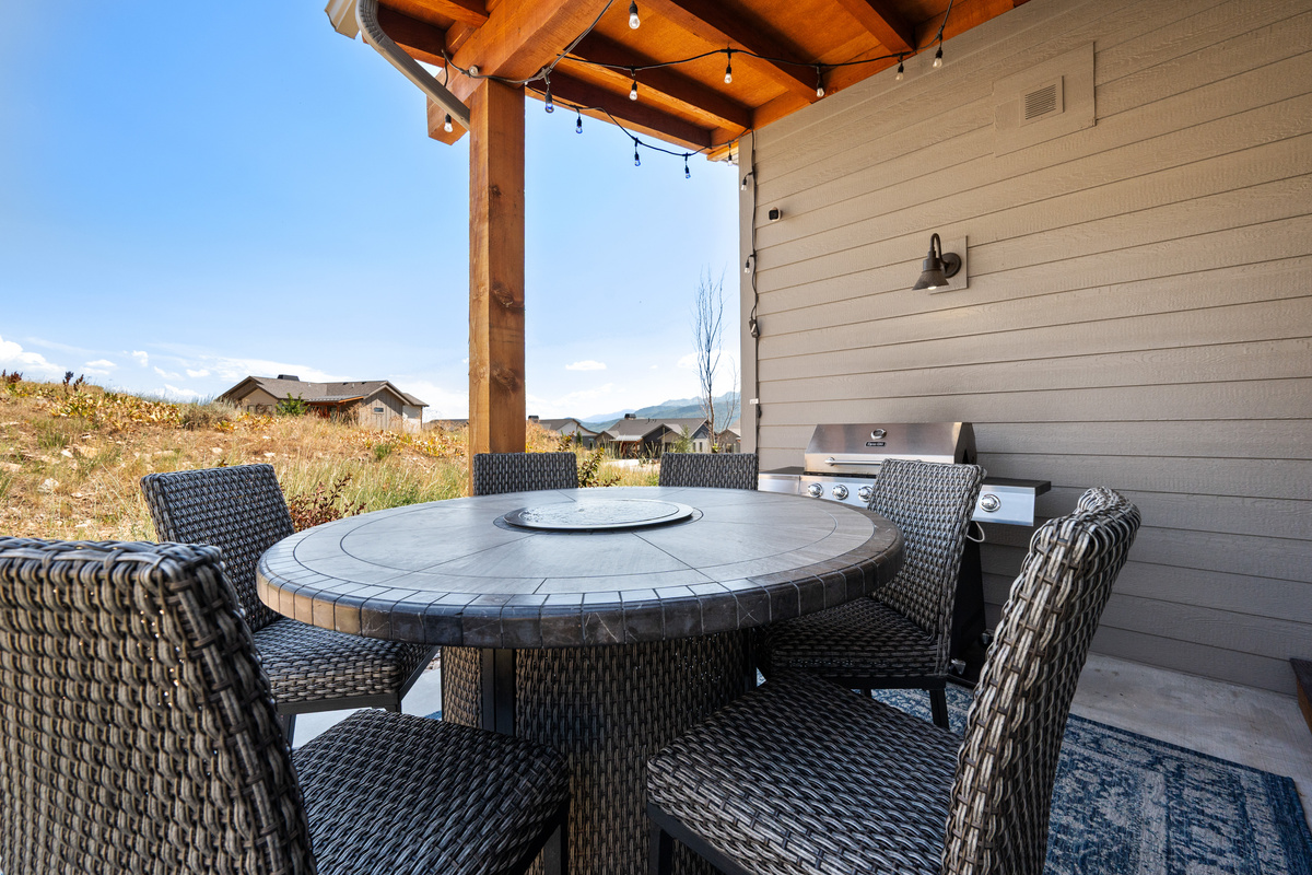 Covered outdoor dining patio with peaceful backyard setting