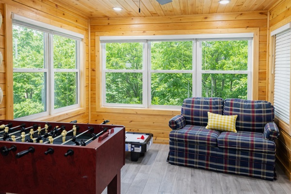 Game room featuring a foosball table, mini air hockey, board games, and seating with sliding door access to the patio. Rainy days are covered here!