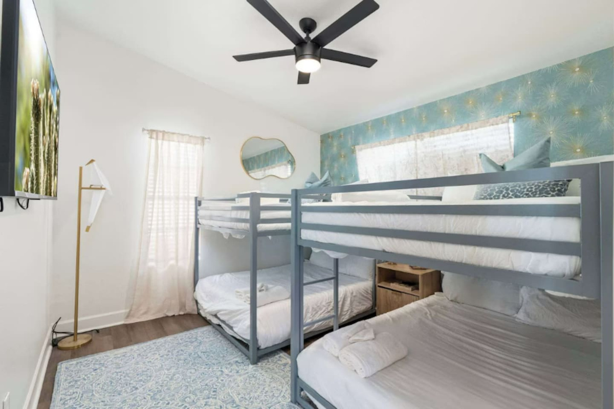 Bunk room with dual bunks, soft blue accent wall, and natural light—perfect for families or groups of friends.