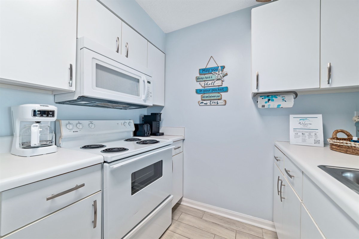 This fully functional kitchen boasts stainless steel appliances, sleek countertops, a decorative backsplash, and ample cabinet storage, ideal for everyday cooking and entertaining.