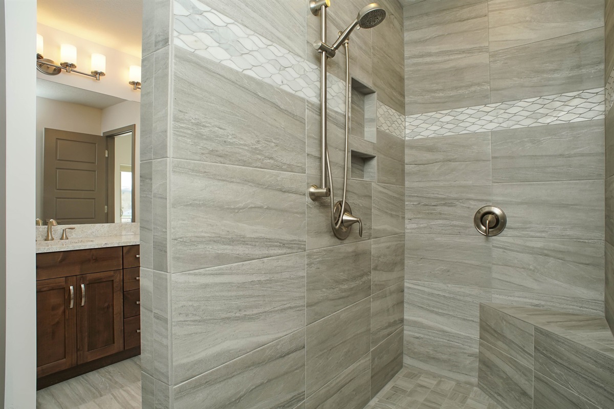 An oversized walk-in shower with elegant tilework delivers a sleek, modern bathing experience.