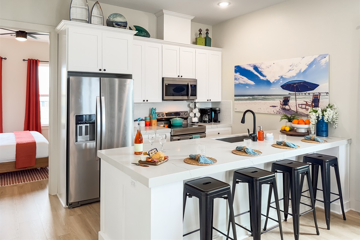 The fully stocked kitchen has 4 additional bar seats by the island.