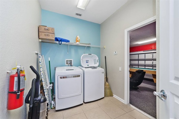 Laundry Room with iron, ironing board, vacuum and broom.