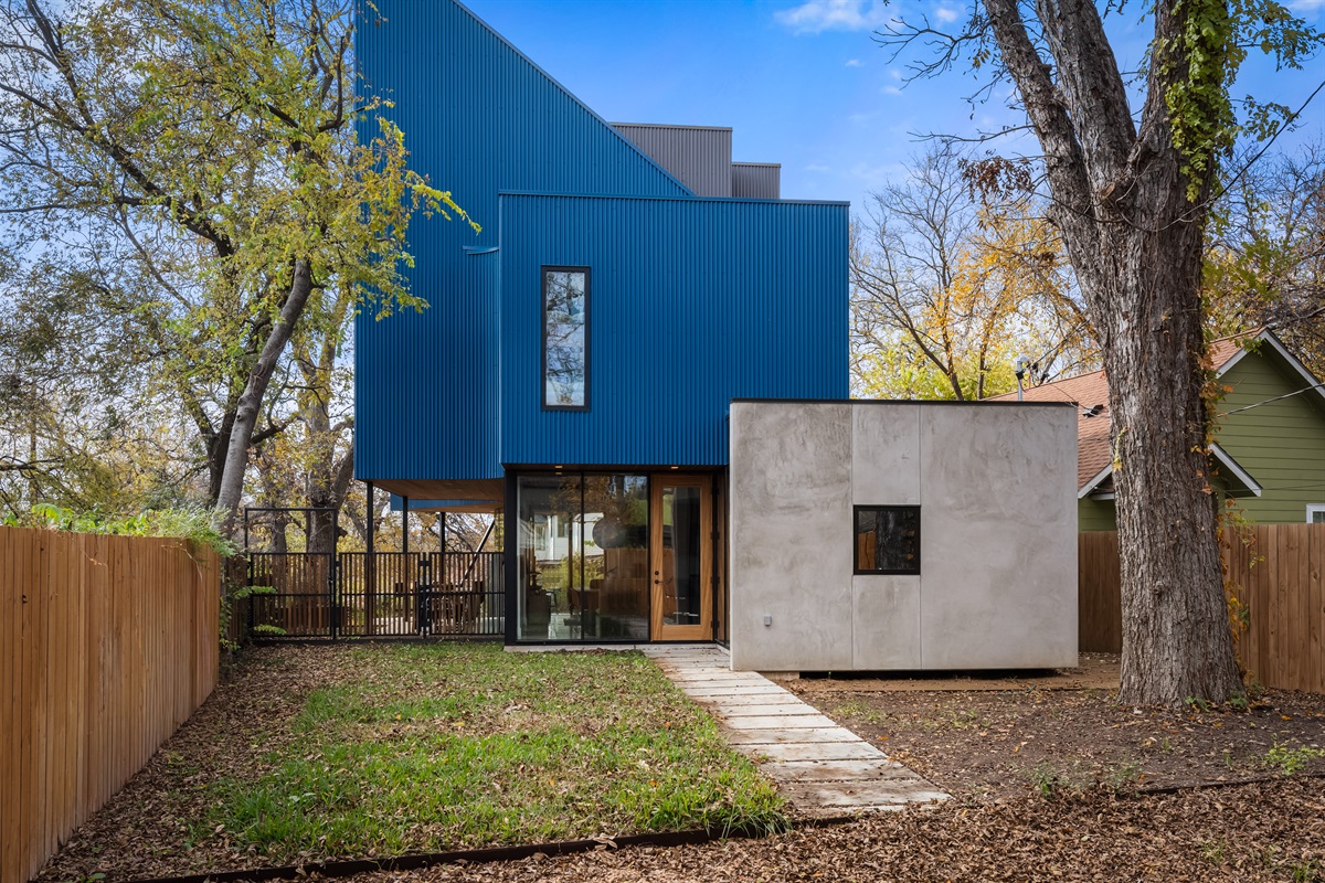 Rear exterior view highlighting the home’s modern design and private fenced yard—ideal for relaxing or gathering outside.