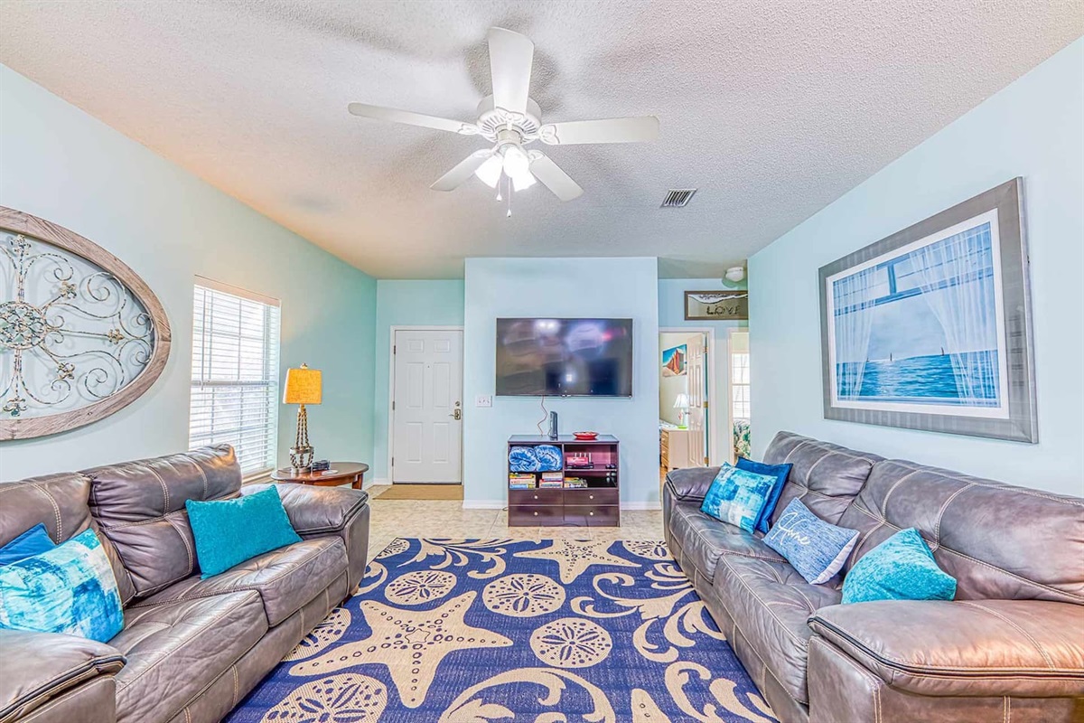 Living Room: Bright, beachy vibes with plush seating and vibrant decor for your ultimate relaxation!