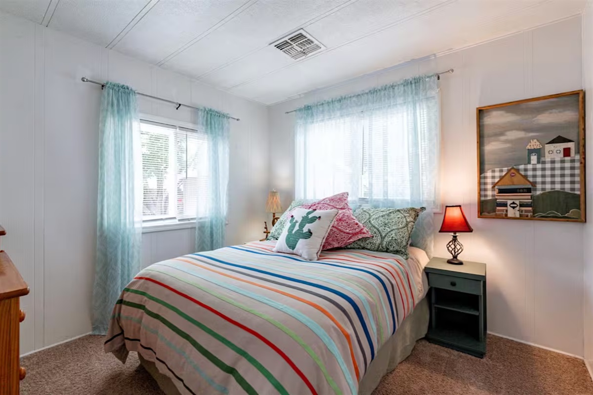 Wake up refreshed in this bright, cozy retreat with soft natural light. Bedroom three with queen size bed.