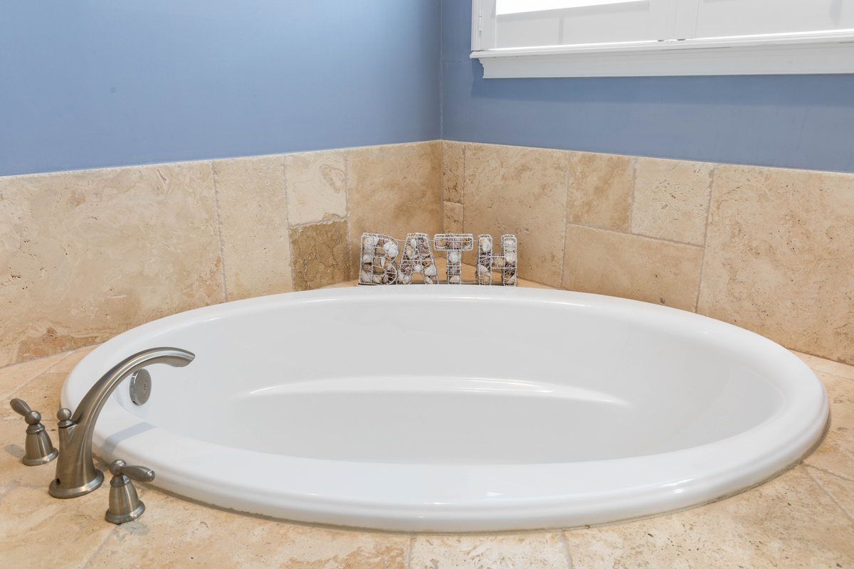 Oval soaker tub set in travertine, just right for a long, warm bath after a day in the sun and salt air.