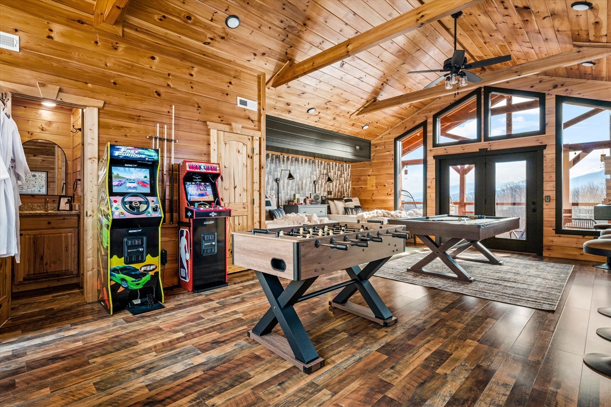 Spacious game room with pool table, foosball, and arcade games with mountain views