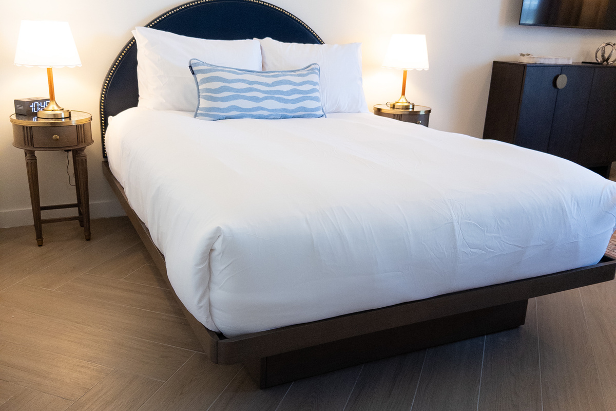 Sink into the king-size bed beneath a navy upholstered headboard with bedside lighting.