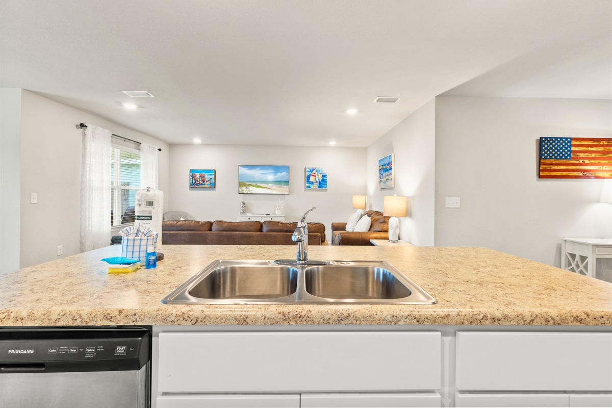 Spacious counter and double sink with living area views—perfect for cleanup while staying connected.