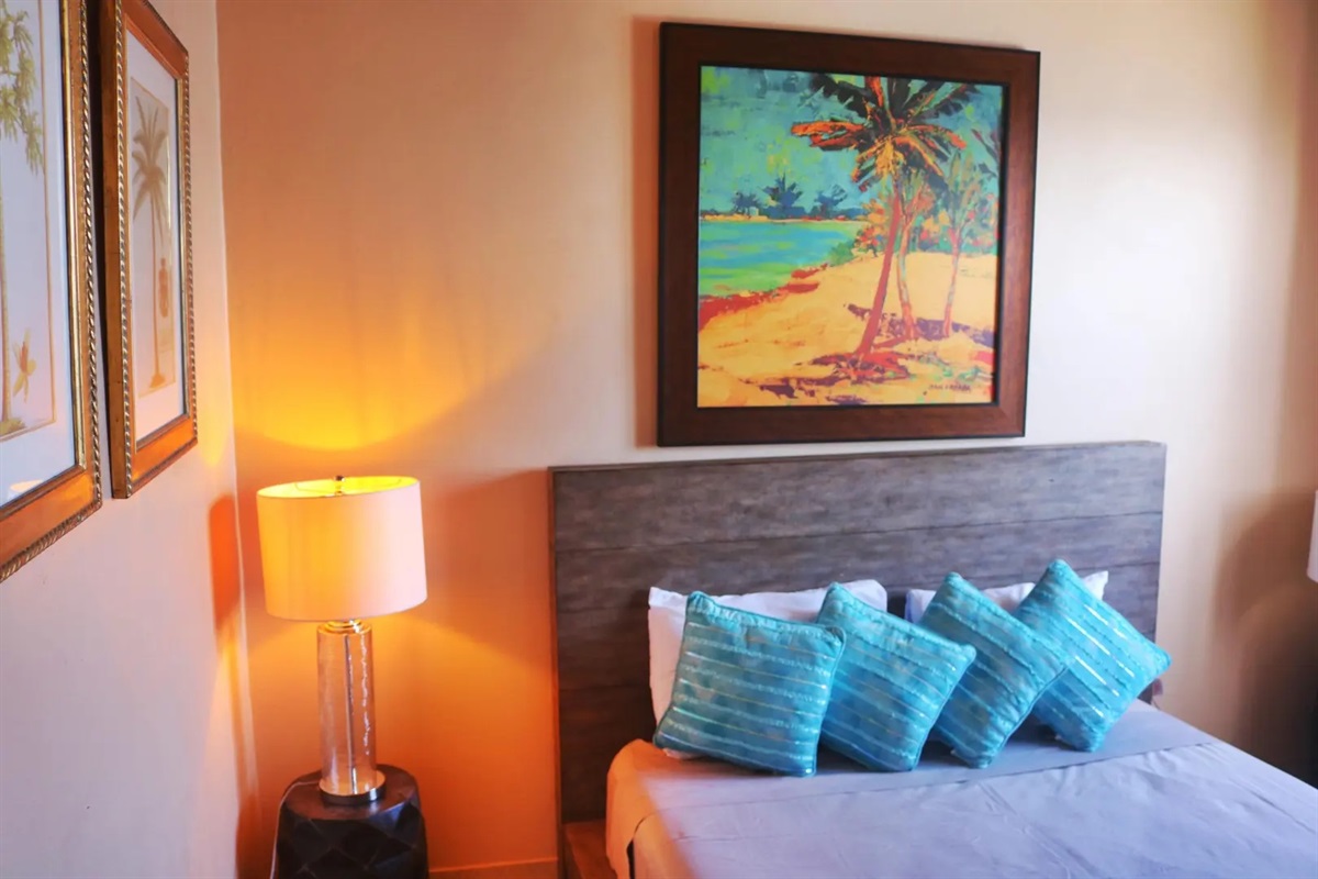 Spacious guest bedroom with A/C and calming décor—quiet, cool, and restful after beach days.