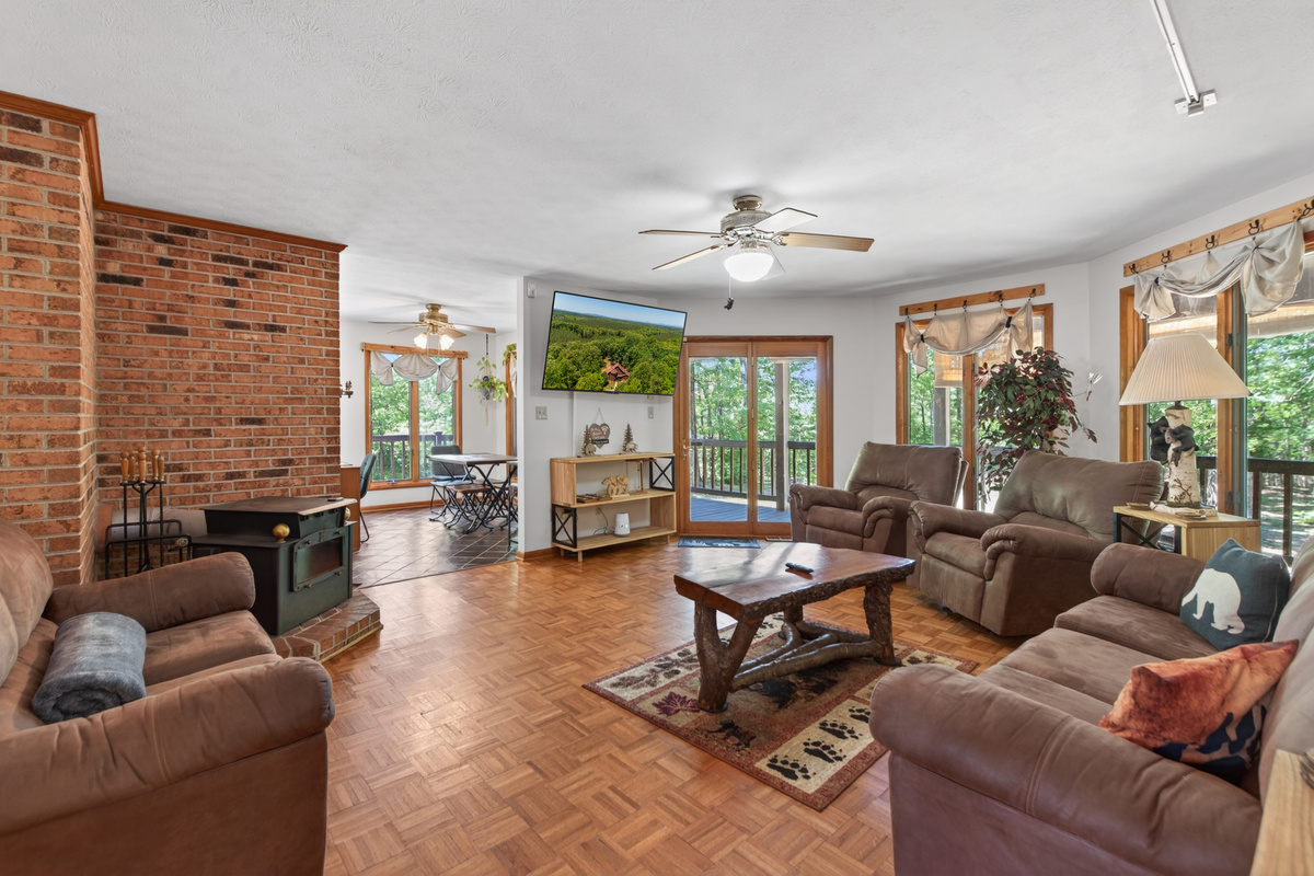 Living Room: Bright space with scenic views, plush seating, and a cozy fireplace for gatherings!