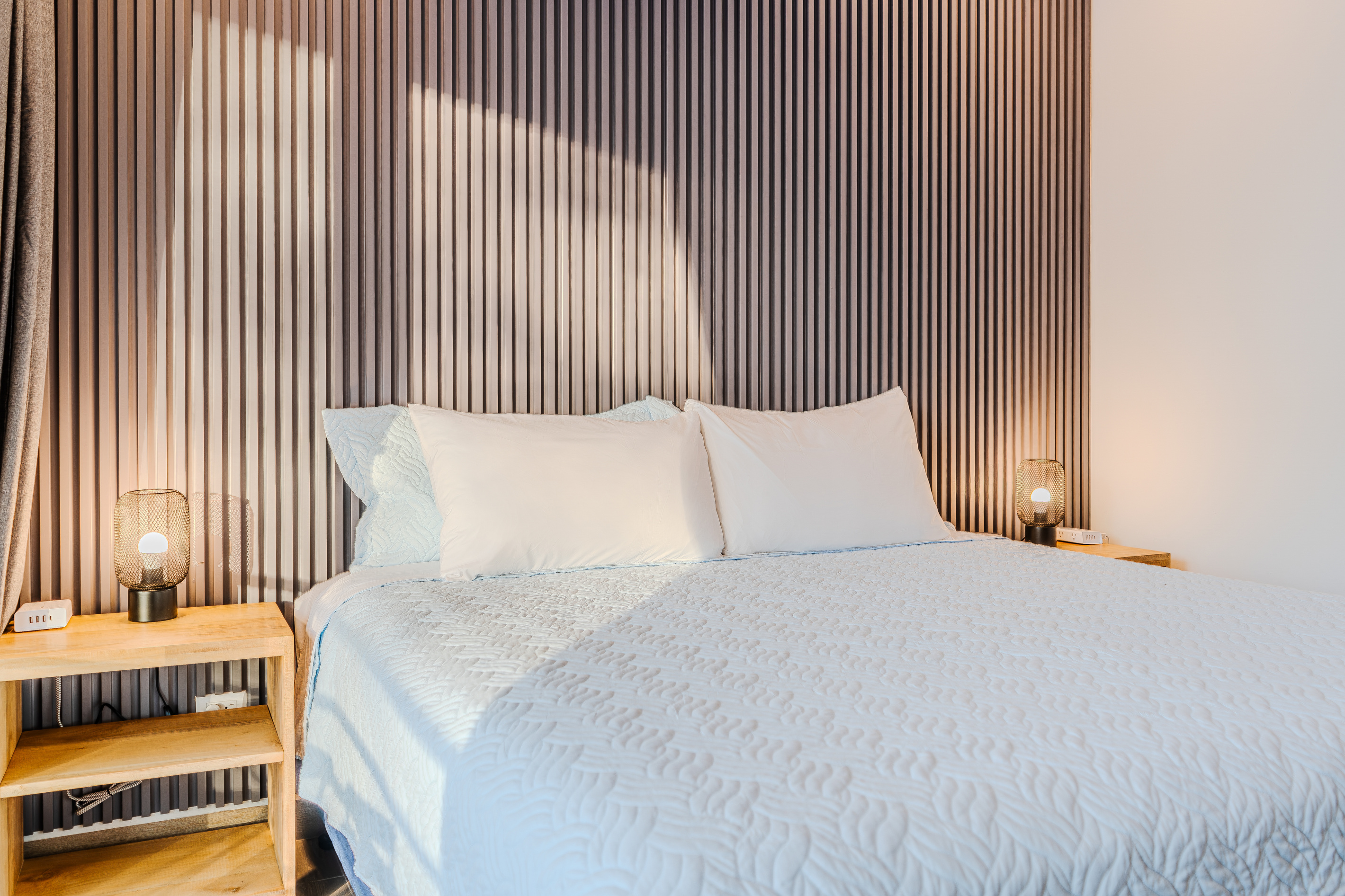 Second king bedroom. Grey accent wall, golden hour light.