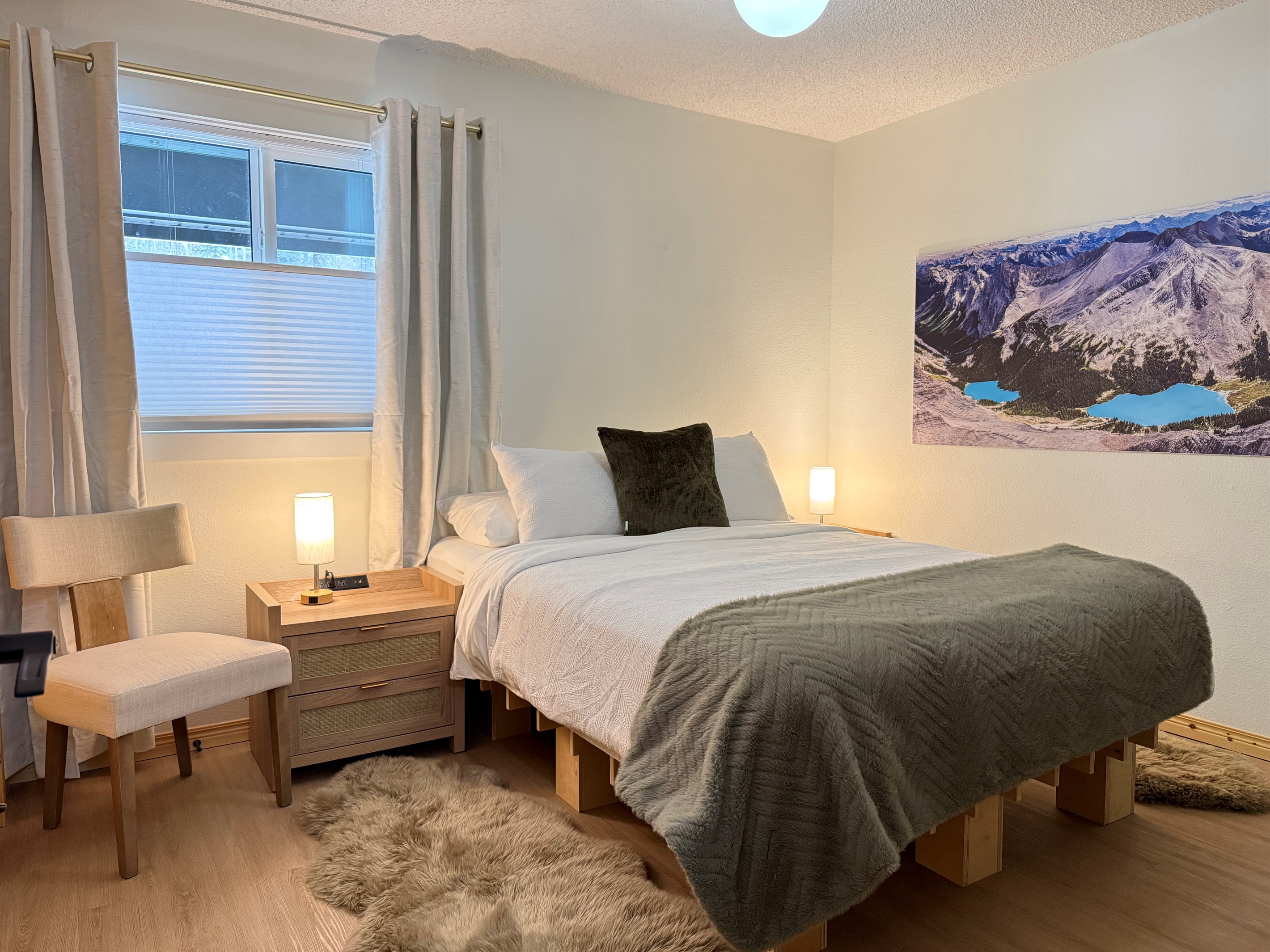 Cozy queen bed with dual nightstands featuring outlets, USB and USC ports, and dimmable touch lamps for a comfortable, connected stay. 