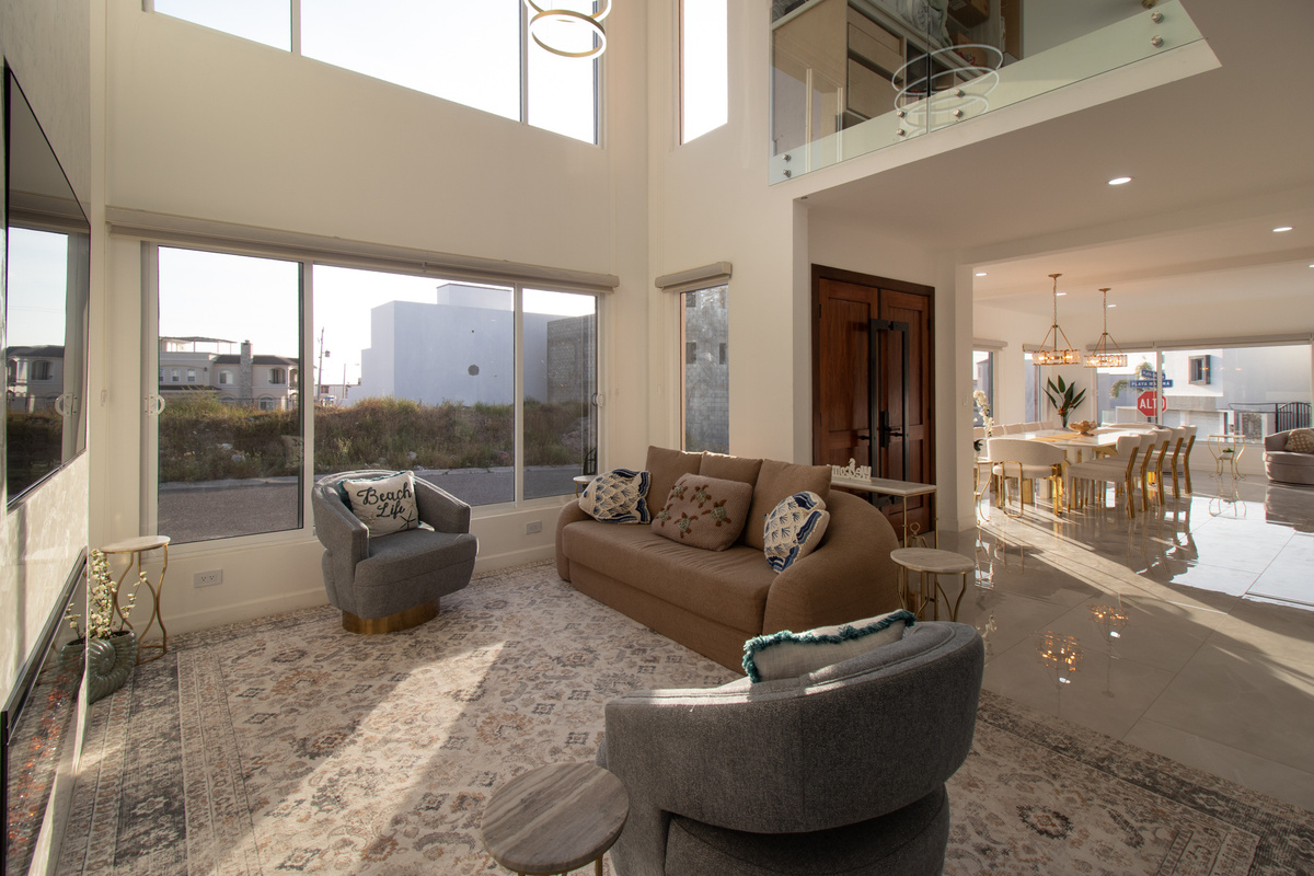 Soaring two-story great room with floor-to-ceiling windows & plenty of space to gather