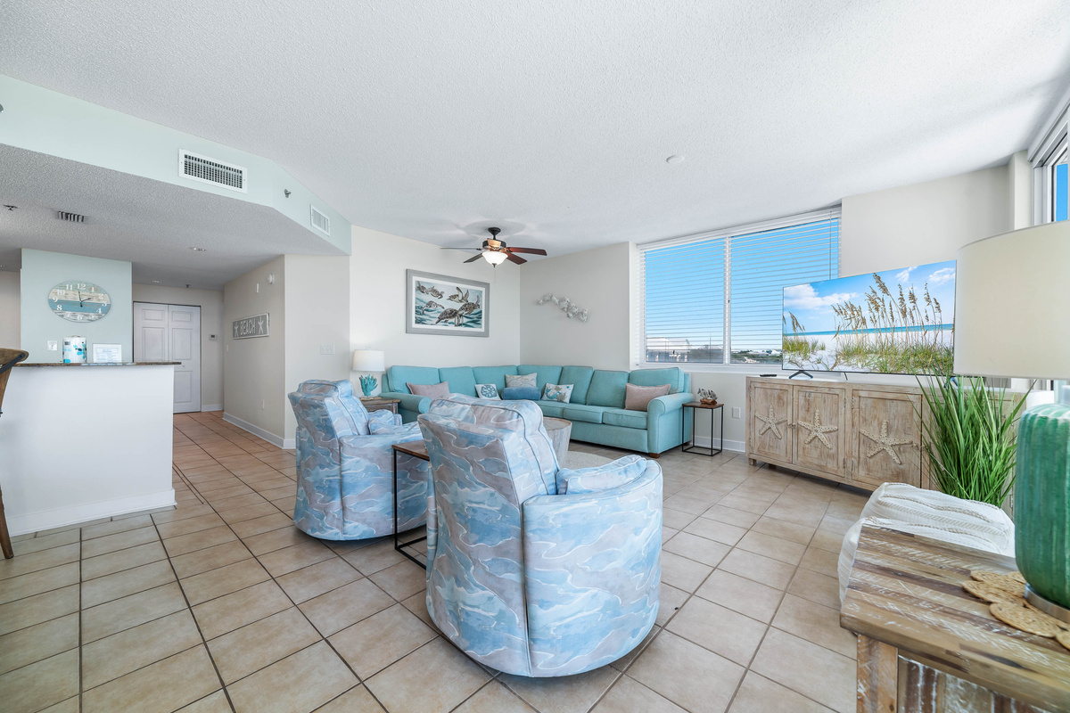 A comfortable living room with ample seating, flowing into a dining area, ideal for everyday living and gatherings.