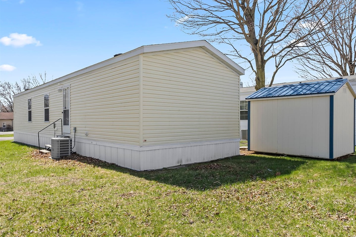 Full exterior perspective showing the home, yard in a quiet residential setting.