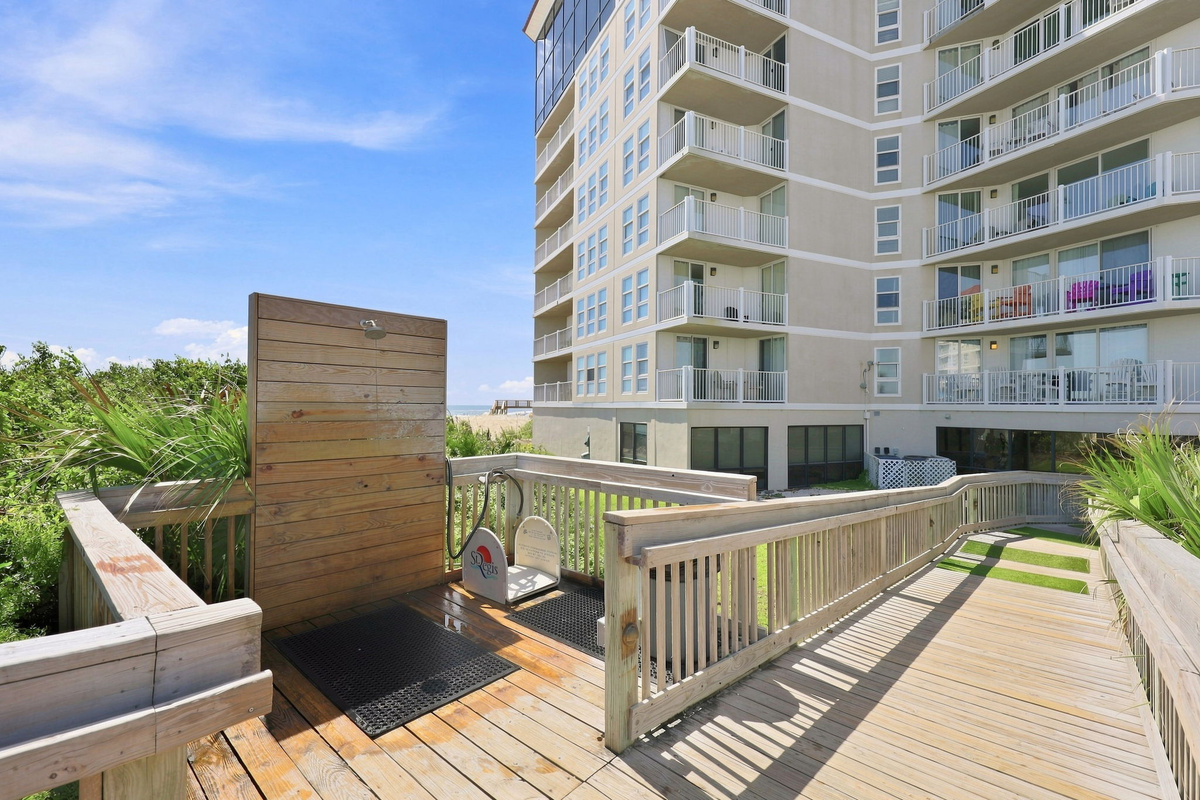 Ground-level wooden deck and gate area providing an exterior passageway right outside the resort building.