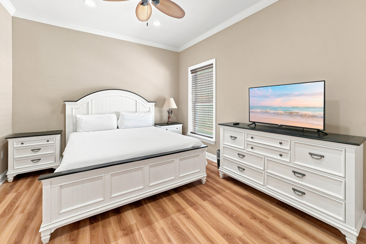 Bedroom with a smart TV and a water-view window