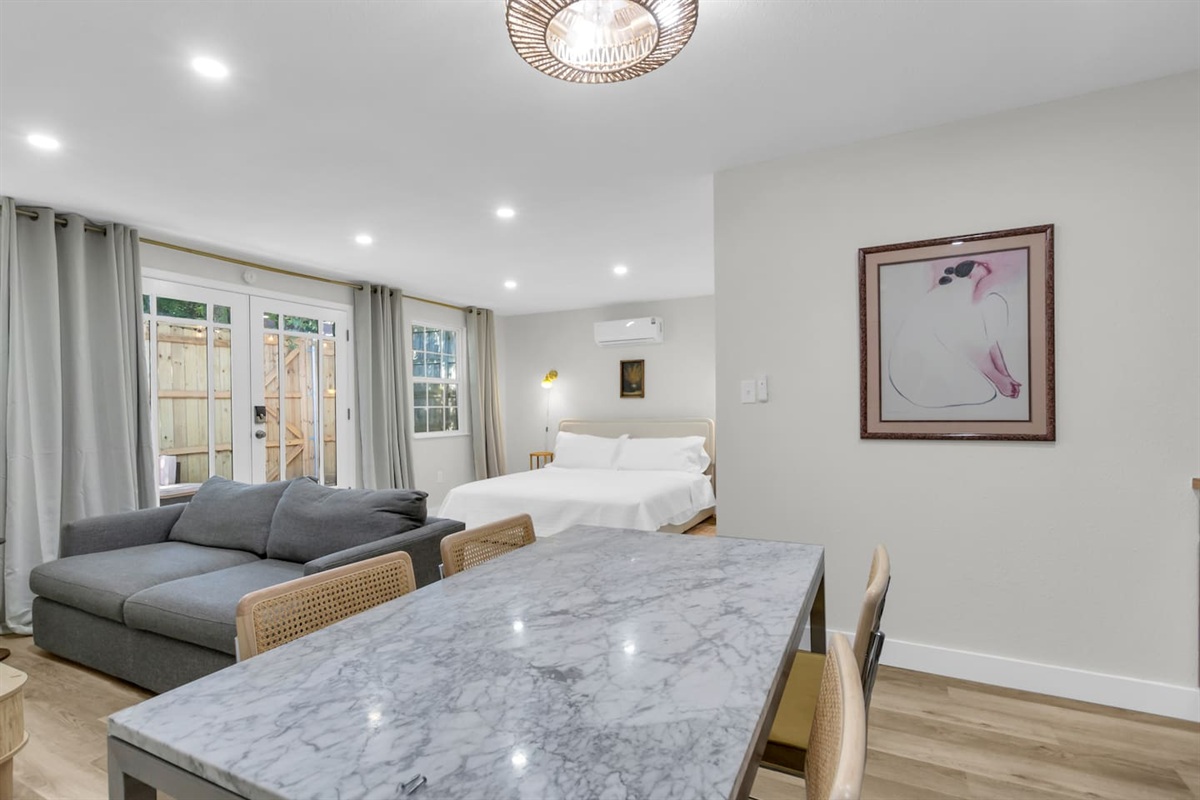 Enjoy meals or unwind with a glass of wine at the dining table for four, set within this stylish open-concept studio kitchen.