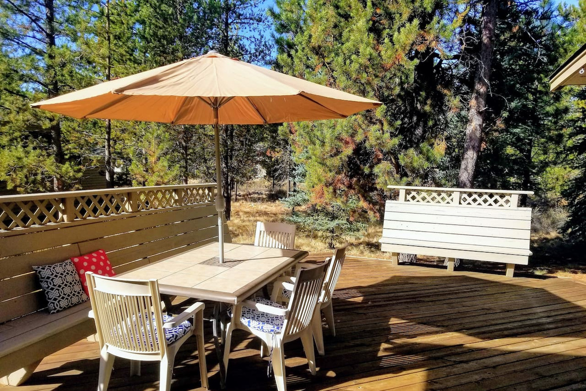 The deck also has plenty of seating for all with a full-length bench, and the view highlights  the perks of a quarter acre lot!  A bike path is located out past the trees a ways. 