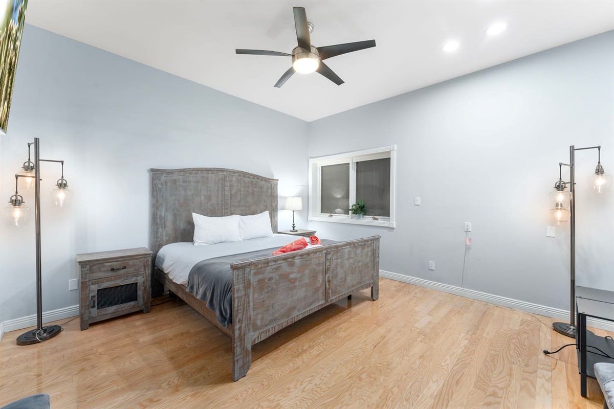 Spacious retreat with a king-size bed, modern ceiling fan, and flat-screen TV for your entertainment