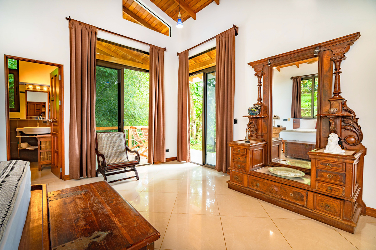 King bedroom suite with tropical hardwood furnishings and floor-to-ceiling glass doors