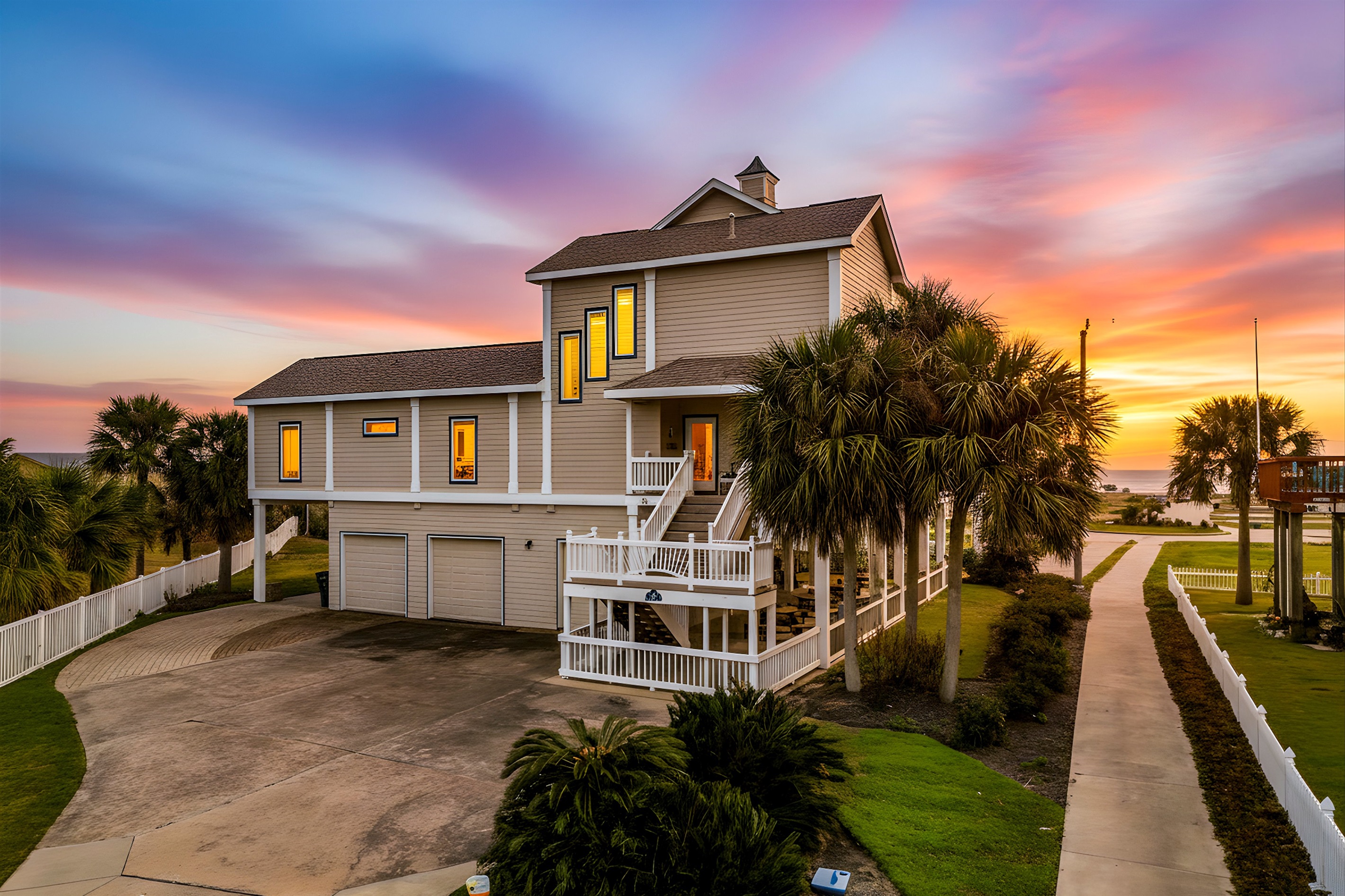 Exterior View: Experience stunning sunsets from your beachfront getaway oasis with garage parking and plenty of outdoor space for parking!