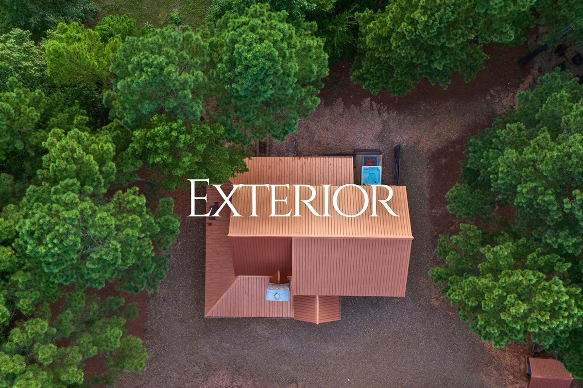 Bird’s-eye view of the cabin’s private forest setting and ample parking space.
