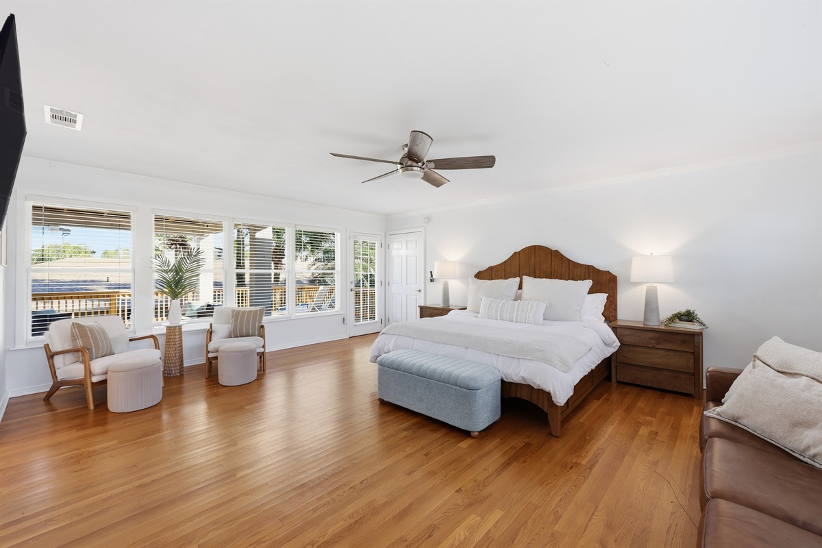 Luxury primary suite with seating area and beautiful natural light