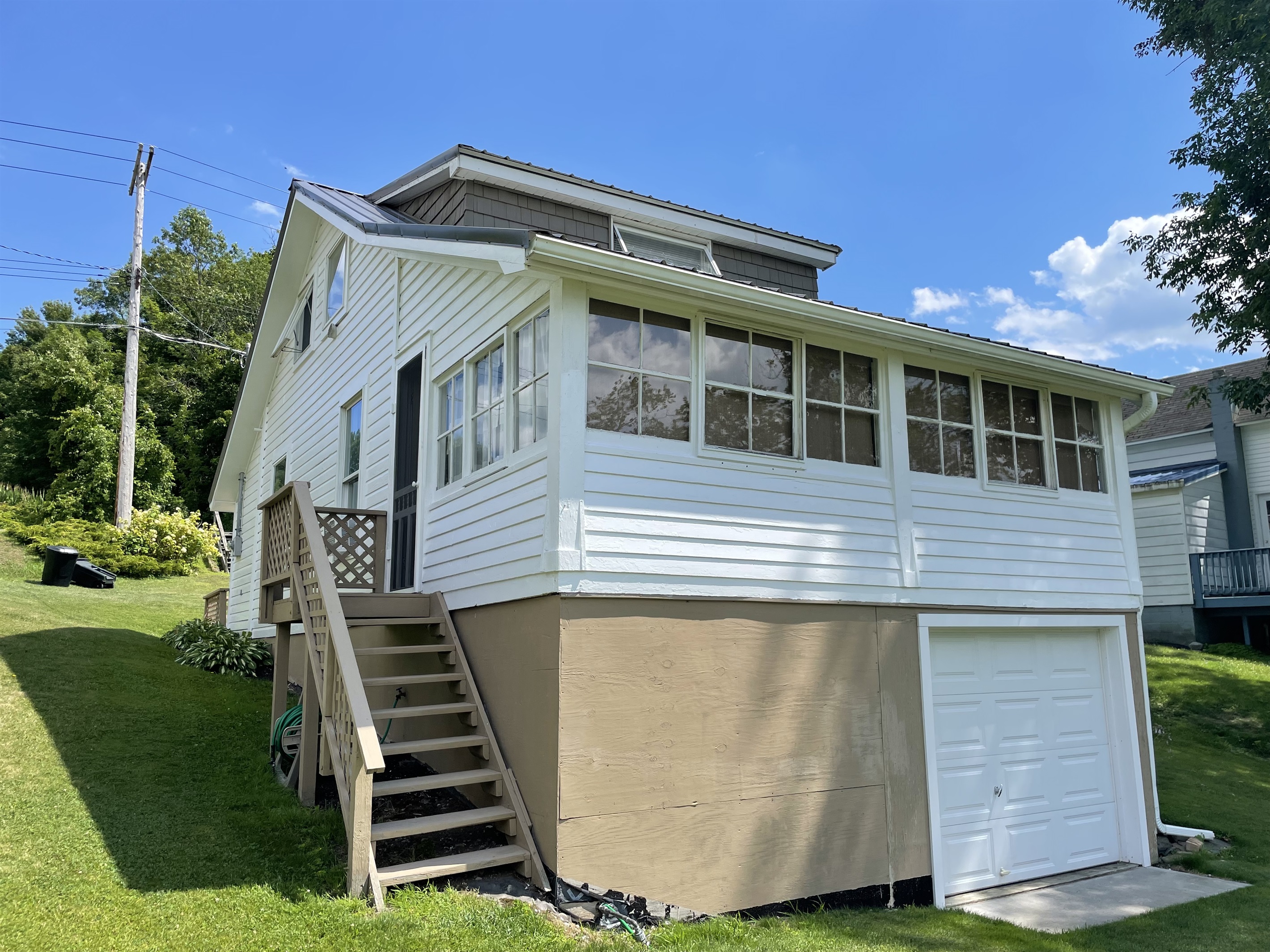Side door off of sunroom leading to lawn and lake