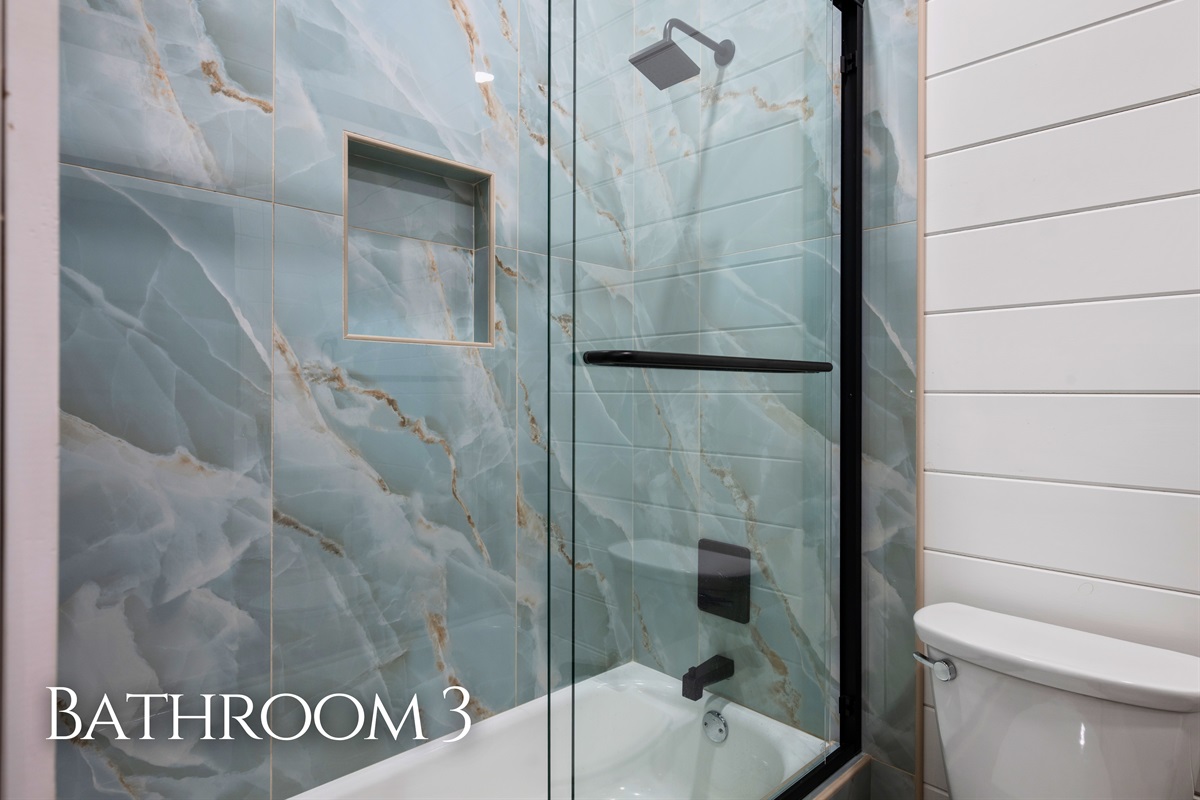 A sleek shower-tub combo with eye-catching tile creates a refreshing and modern bathroom space designed for comfort.