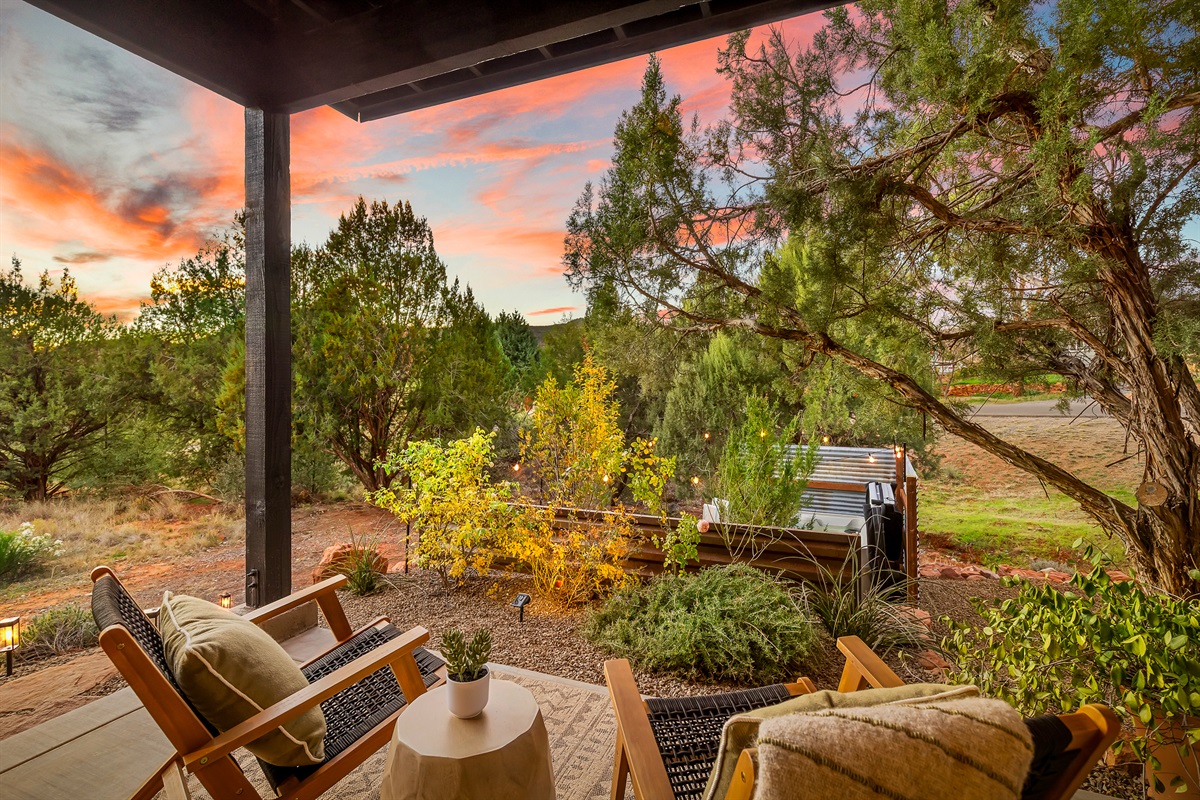 Cozy guesthouse patio with lounge seating and sunset views, overlooking the private 2-person hot tub and Sedona desert landscape. 